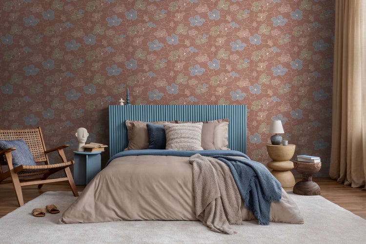 Schlafzimmer mit Vliestapete mit floralem Muster in einem modern eingerichteten Raum mit Bett und Holzstuhl.