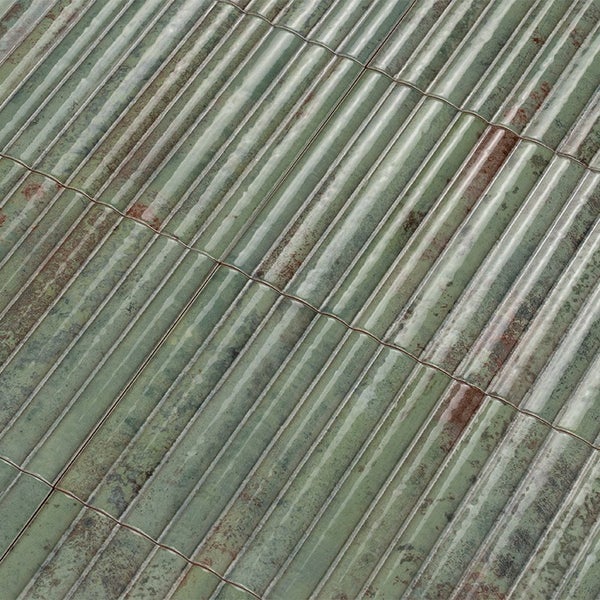 Wandfliesen mit geriffelter Struktur und glänzender Oberfläche in grüner Optik mit rustikalem Finish.