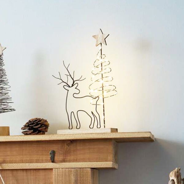 Dekorative Weihnachtsfiguren aus Metall und Holz auf einem Regal.