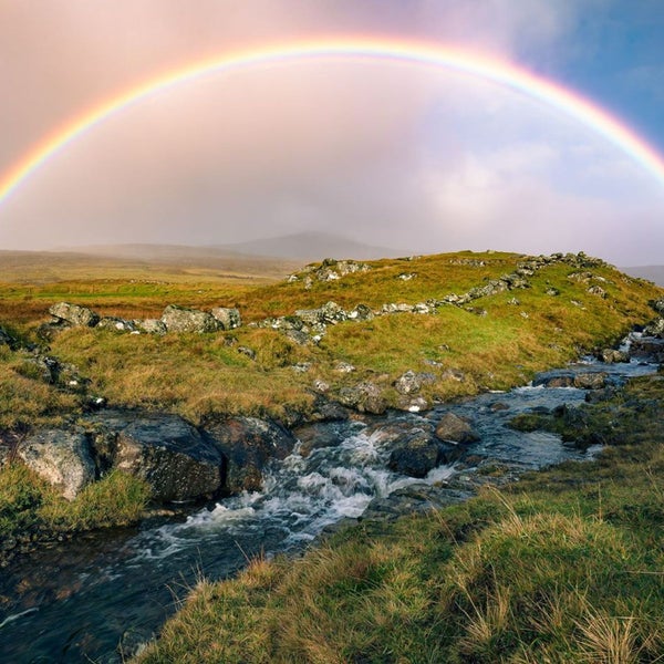 Landschaft mit Bachlauf, Felsen und Regenbogen