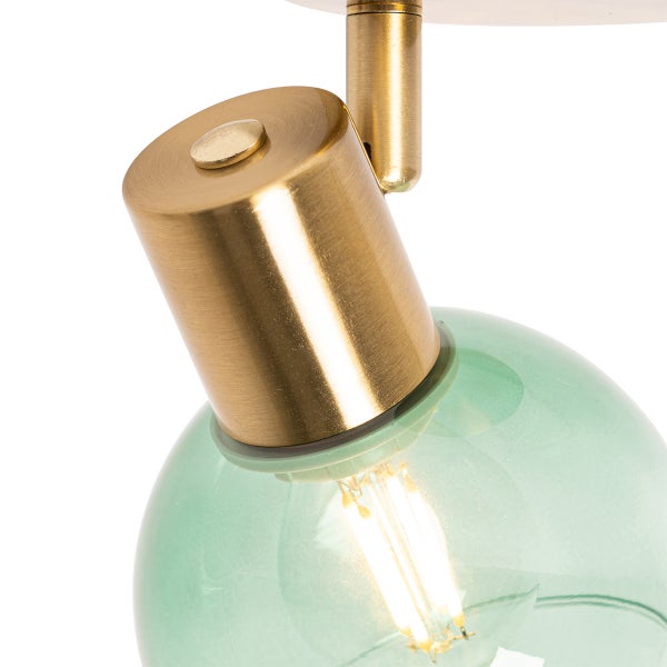 Detailansicht einer Deckenleuchte mit grünem Glasschirm und goldfarbenen Metallakzenten.