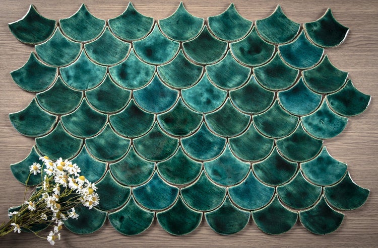 Grüne Mosaikfliesen in Schuppenform auf einer Holzoberfläche