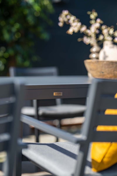 Nahaufnahme der Kante eines Gartentischs mit Garden Impressions Logo.