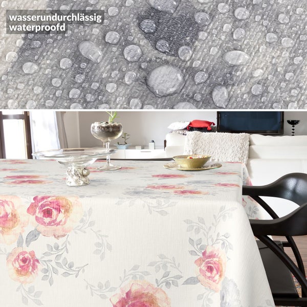 Wasserundurchlässige Tischdecke mit Rosenmuster auf einem Tisch in hellem Wohnraum, Detailaufnahme der wasserabweisenden Oberfläche.