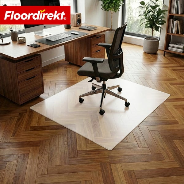 Büro mit Bürostuhl, Schreibtisch und transparenter Bodenschutzmatte auf Holzboden