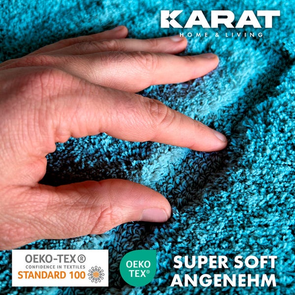 Detailansicht einer türkisfarbenen Badematte mit dem Karat Home and Living Logo, einem OEKO-TEX Standard 100 Siegel und dem Hinweis Super Soft Angenehm