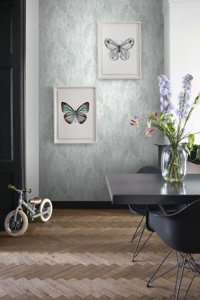 Wohnraum mit Blättertapete, Esstisch und Kinderfahrrad