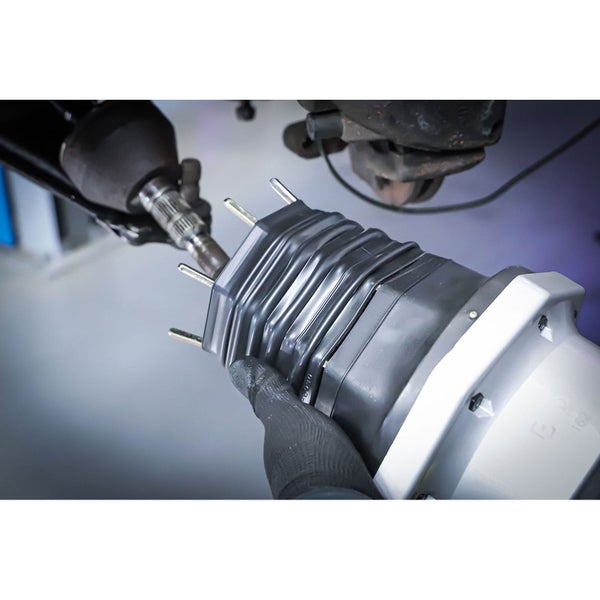 Manschettenspreizer in Aktion mit Automobilkomponenten im Hintergrund