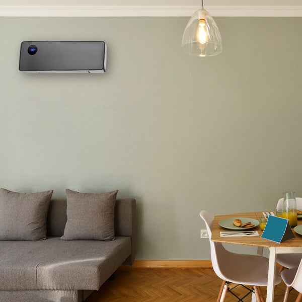 Wohnzimmer mit Klimaanlage, Sofa und Esstisch.