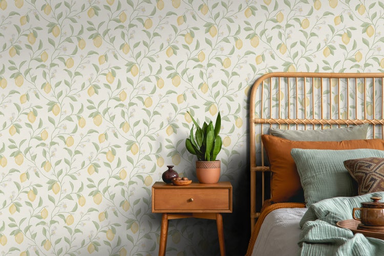 Schlafzimmer mit Rattanbett, Nachttisch und Tapete mit Zitronenmuster