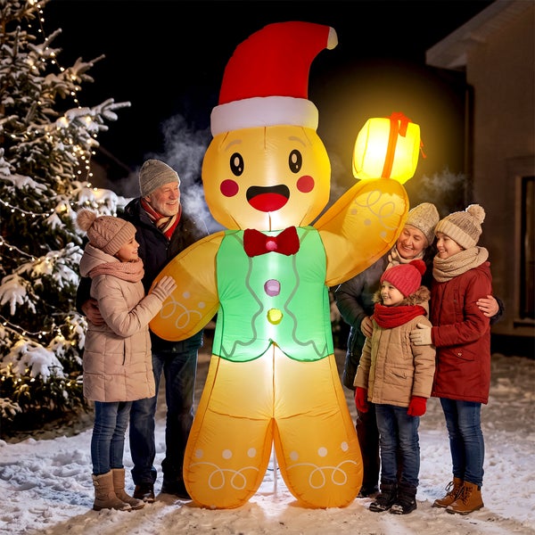 Familie steht im Schnee neben einem beleuchteten, aufblasbaren Lebkuchenmann als Weihnachtsdekoration für den Außenbereich.