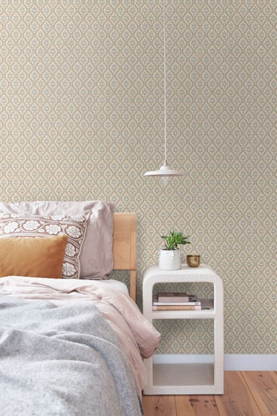 Helles Schlafzimmer mit Vliestapete mit ornamentalem Muster, Holzbett, Nachttisch und Pendelleuchte.