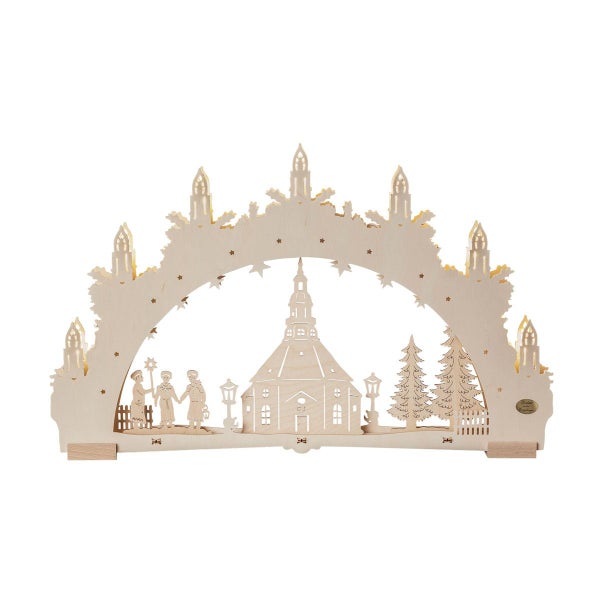 Beleuchteter Schwibbogen aus Holz mit winterlicher Dorfszene, Kirche, Tannen und Figuren als weihnachtliche Dekoration.