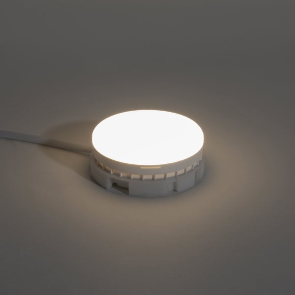 Runde LED Möbelleuchte für die Oberflächenmontage, eingeschaltet, mit Anschlusskabel.