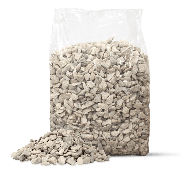 Grauer Ziersplitt in einem transparenten Kunststoffsack mit einer kleinen Menge loser Steine davor.