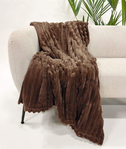 Braune Kuscheldecke mit gerippter Textur auf einem Sofa
