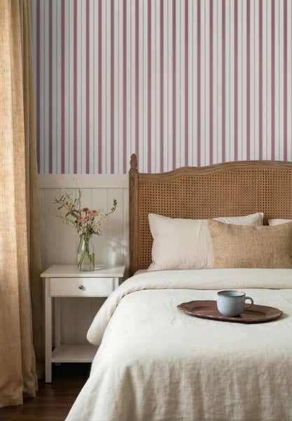 Vliestapete mit vertikalem Streifenmuster in einem hellen Schlafzimmer mit Holzbett und weißem Nachttisch.