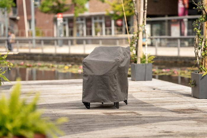 Abgedeckter Gartenstuhl mit Schutzhülle auf einer Holzterrasse