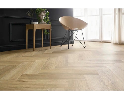 Heller Holzboden im Fischgrätenmuster in einem stilvollen Raum mit Fenster, Stuhl und Beistelltisch.