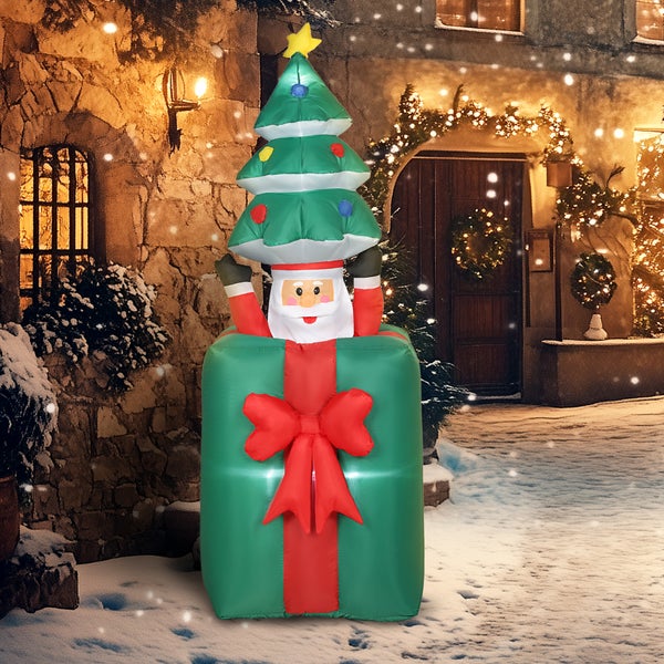 Aufblasbare Weihnachtsdekoration: Weihnachtsmann hält Tannenbaum und kommt aus grünem Geschenk mit roter Schleife, beleuchtet.