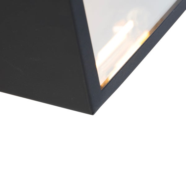 Nahaufnahme einer modernen Außenwandleuchte mit schwarzem Metallrahmen und Glasscheibe mit leuchtendem Filament.