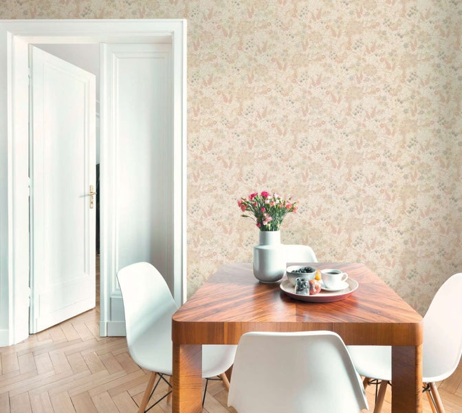 Wohnzimmer mit Vliestapete mit Blumenmuster an einer Wand, Holztisch mit Stühlen und Parkettboden in heller Wohnumgebung.