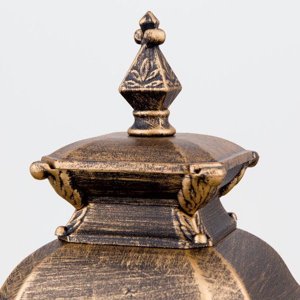 Nahaufnahme der verzierten Spitze einer Außenlampe im antiken Design.