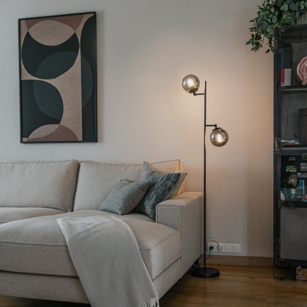 Wohnzimmer mit Sofa, Stehlampe und Dekorationen für eine gemütliche Atmosphäre.