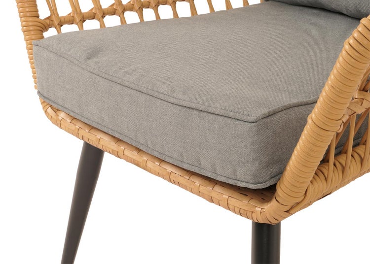 Detailansicht eines Rattansessels mit Sitzkissen und Beinen