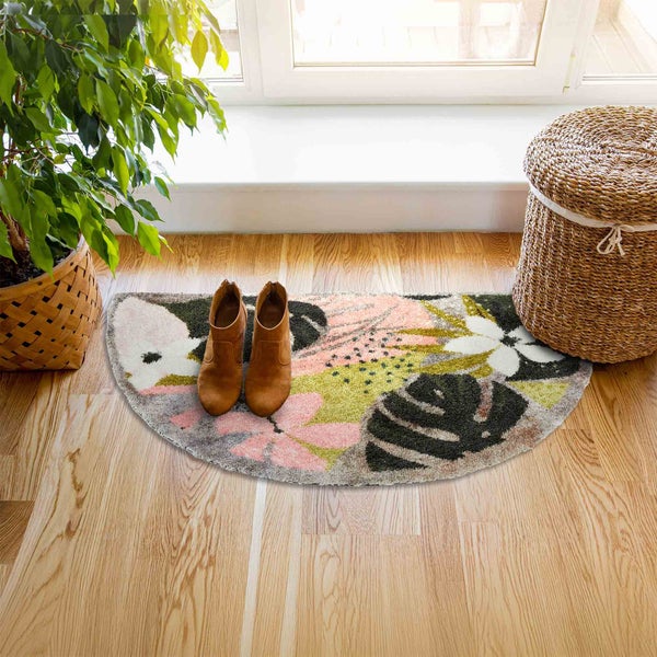 Dekorative Fußmatte mit Pflanzenmuster, Schuhe und Pflanzen im Topf in einem hellen Raum