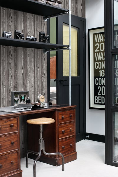 Büro mit Holzschreibtisch, Regal mit Dekoration, Holztapete und Drehstuhl