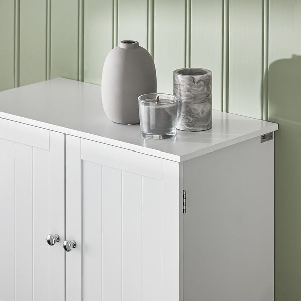 Weißer Badschrank mit Vase, Kerze und Kerzenhalter