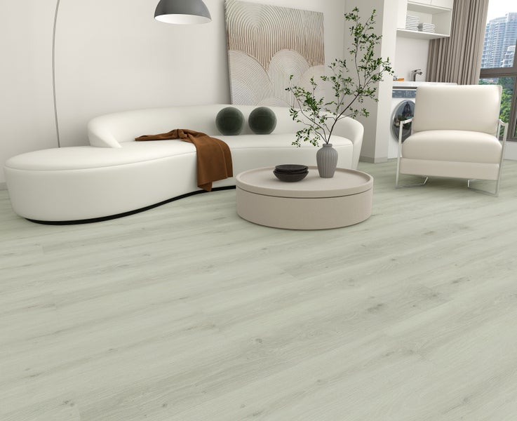 Helle Bodenplanken in Holzoptik in einem modern eingerichteten Wohnzimmer mit geschwungenem Sofa und rundem Couchtisch.