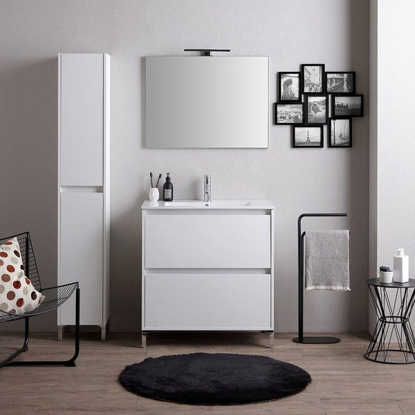 Helles, modernes Badezimmer mit weißem Waschbeckenunterschrank, hohem Seitenschrank, Wandspiegel, schwarzem Handtuchhalter und rundem schwarzem Teppich.