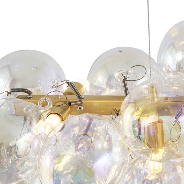 Detailansicht einer Hängelampe mit transparenten Kugeln und goldfarbenen Elementen.