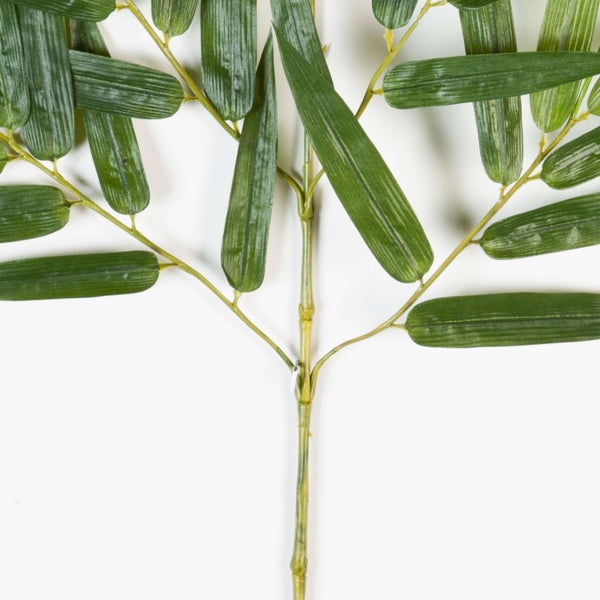 Künstlicher Bambuszweig mit grünen, strukturierten Blättern und segmentiertem Stiel.