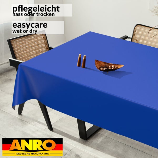 Blaue Tischdecke auf einem Esstisch, pflegeleicht nass oder trocken abwischbar, moderne Einrichtung mit Rattanstühlen, ANRO Logo.