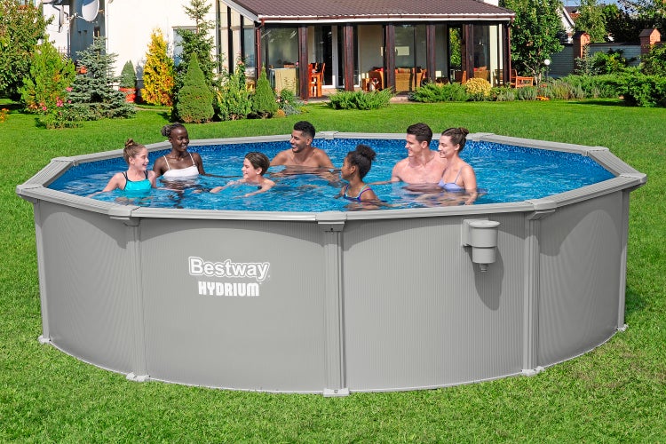 Bestway Hydrium Stahlwandpool in einem hellen Garten mit einer Gruppe von Menschen. Rundes Aufstellbecken auf einer Rasenfläche.