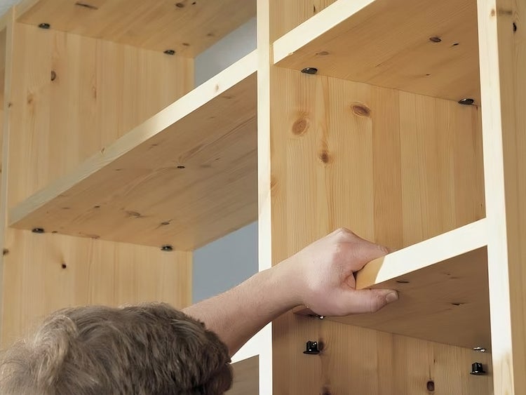 Montage eines Regalbodens in ein modulares Regalsystem aus Massivholz.