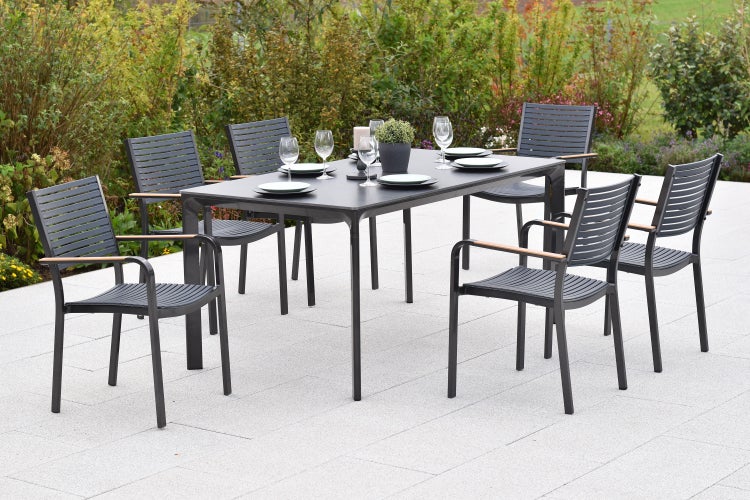 Gartentisch mit sechs Stühlen auf einer Terrasse mit Tischdeko und Garten