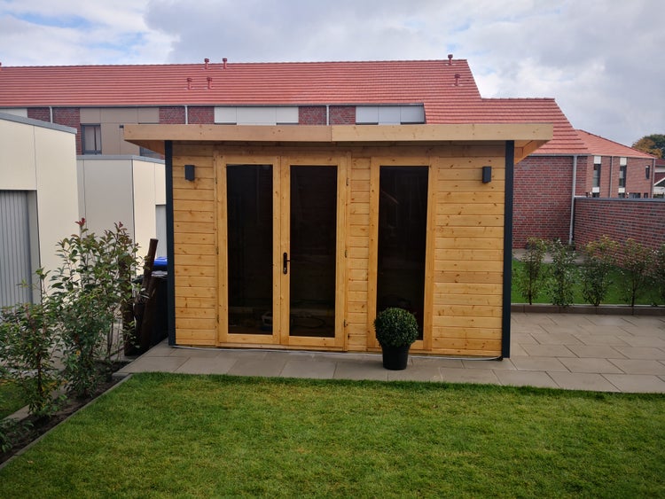 Modernes Gartenhaus aus Holz mit Flachdach und großen Glasfronten auf einer Terrasse im Garten.