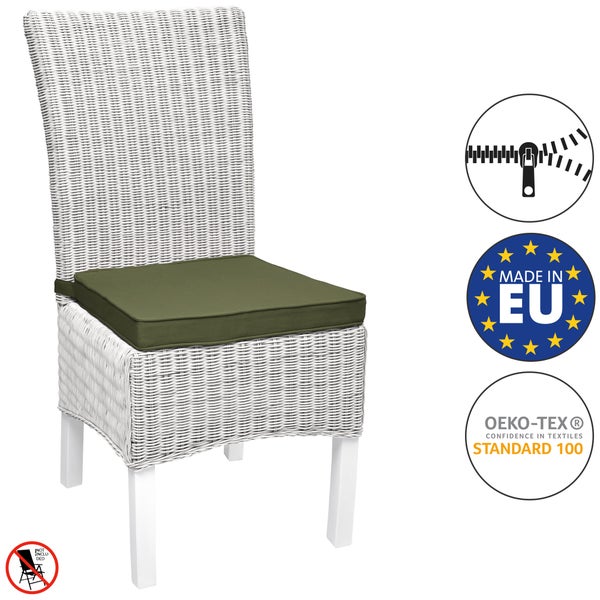 Sitzgruppe mit zwei grauen Rattan-Stühlen, grünen Kissen und passendem Couchtisch auf hellem Teppich vor dunkler Holzwand.