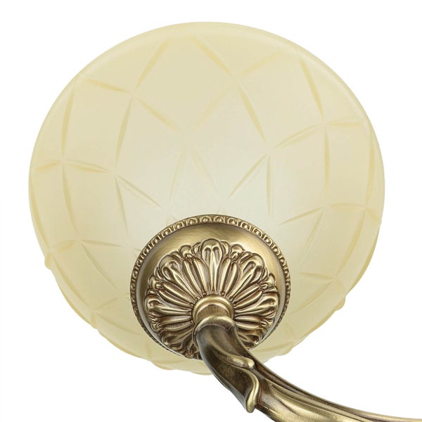 Nahaufnahme einer Deckenleuchte mit Lampenschirm aus Glas und Metallelementen