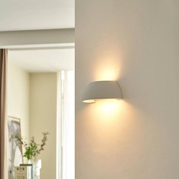 Moderne Wandleuchte mit halbkreisförmigem Design, strahlt Licht nach oben und unten ab, helle und organisierte Atmosphäre.