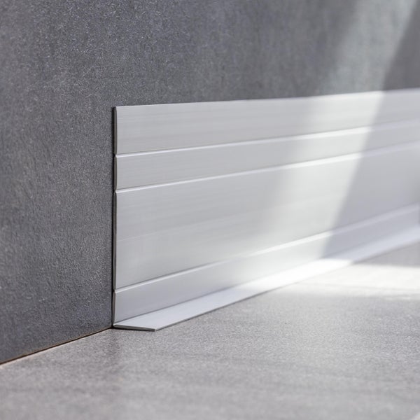 Sockelleiste aus Aluminium an einer gefliesten Wand und Boden.