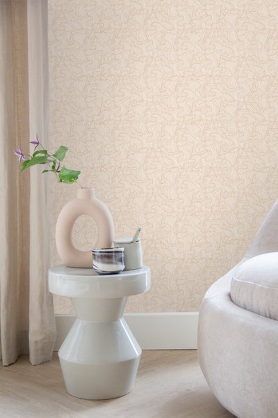 Wand mit abstrakter Mustertapete, Beistelltisch mit Dekorationsgegenständen und Sessel