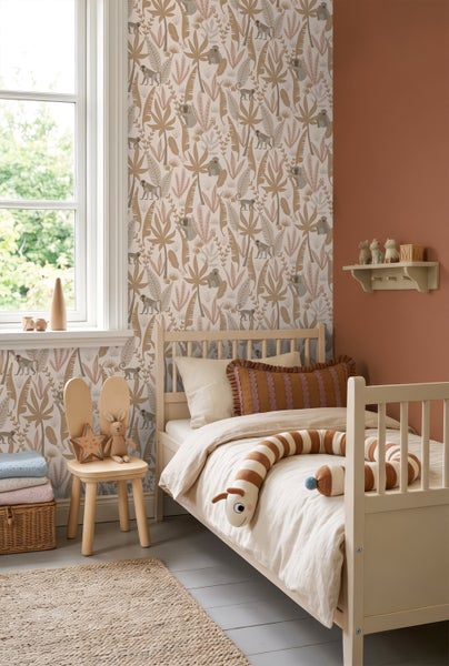 Vliestapete mit Affen- und Blättermotiv in einem hellen Kinderzimmer mit Holzbett und einem Stuhl in Hasenform.