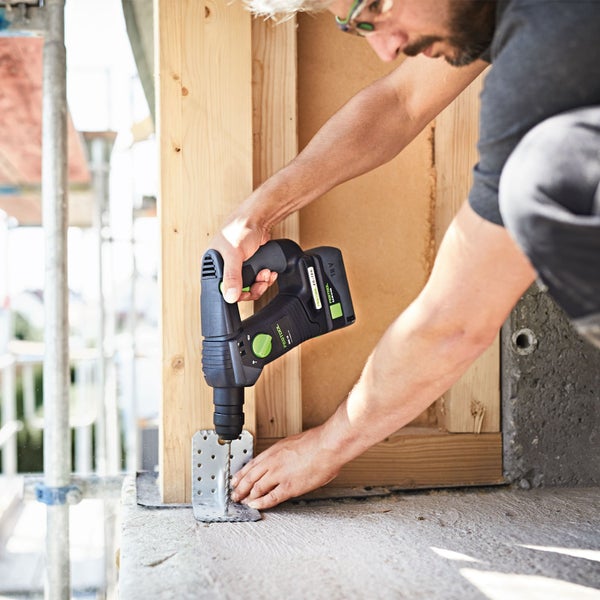 Handwerker verwendet eine Festool Schlagbohrmaschine zum Bohren in Holz
