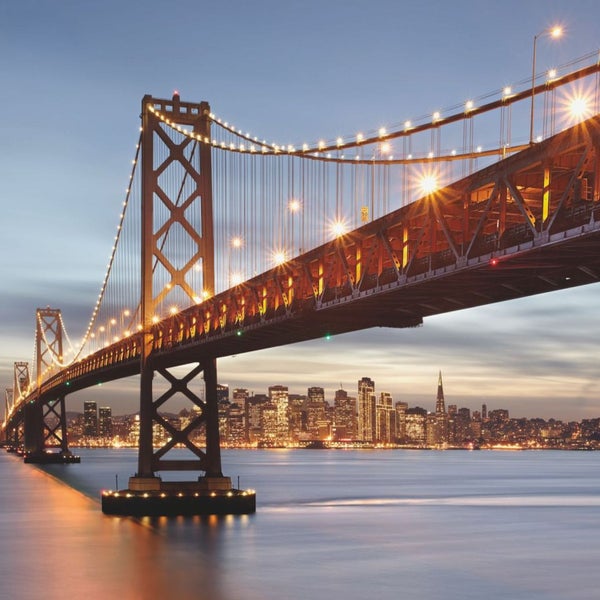 Beleuchtete Brücke mit Stadtbild im Hintergrund