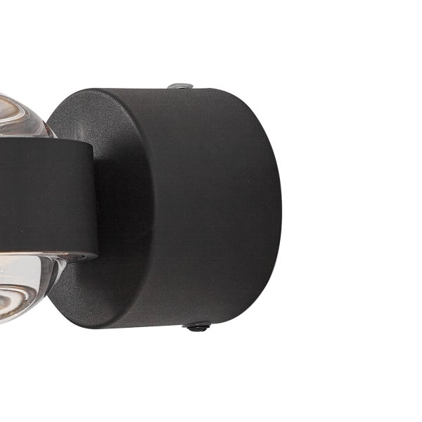 Schwarze zylindrische Wandhalterung einer Leuchte mit Glaselement.